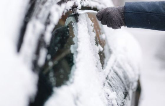 Une Femme Nettoie La Vitre Avec Un Grattoir Pendant Les Gelées La Vitre De  La Voiture Est Gelée